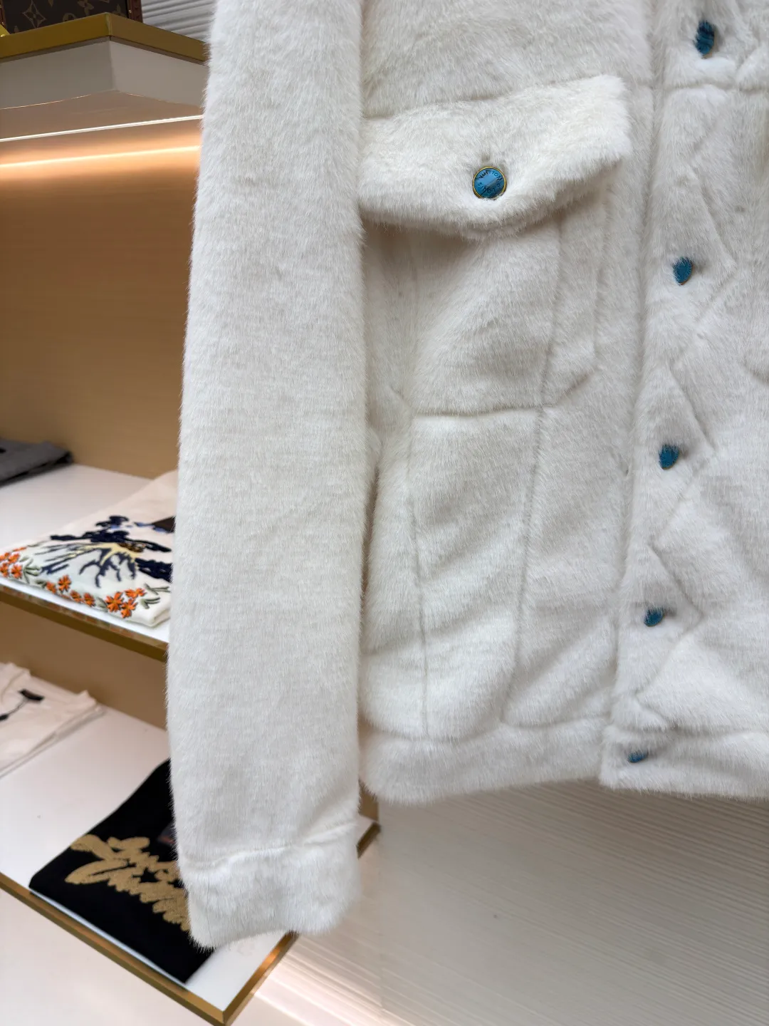 LOUIS VUITTON Turquoise Mink Jacket ●Original version: Purchased and developed at 147799 ●Item number: 1681421-C30 ●Fabric: mink fur fabric ●Technology: embroidery production ●Color: white ●Version: Fitted version ●Weight: about 1065 grams ●Size: 46-48-50-52 ●Description: This jacket is made of high-end imitation mink velvet fabric, which is soft and fluffy to the touch and has excellent warmth retention. The lapel design adopts three-dimensional tailoring + precision sewing technology, and the collar shape is crisp and naturally connected with the body. The placket button is a custom-made blue-green metal button, which creates a visual contrast with the white fabric. It is sewn in precise position and opens and closes smoothly. The large pockets on both sides use three-dimensional bag-shaped technology, and the bag mouth echoes the buttons, combining practicality and design. The inner lining is made of the brand's classic pattern printed fabric, which is combined with the outer layer of plush fabric through laminating sewing technology to create a strong sense of layering. The overall cut is a loose-shouldered version, and the multi-piece structure is spliced ​​to create a casual and trendy wearing effect while ensuring comfort and freedom during movement. It is a fashionable item that combines luxurious plush texture with exquisite craftsmanship. The overall wiring is straight and delicate, the fabric is comfortable and soft, and the color is consistent without color difference. It can be matched with the same style to create a fashionable look and control various occasions. Customized accessories, complete with three standards, same style for men and women!